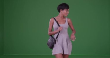 Yeşil ekranda dönen mutlu, gülümseyen kadın. Anahtar ya da birleşik olmak üzere yeşil ekranda.