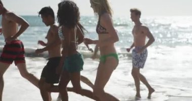 Mutlu grup Interracial arkadaşıyla gülüyor plaj sahil dalgalar çalışan