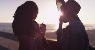 Siyahi kadınların en iyi arkadaşları gün batımında cep telefonlarını kontrol ediyor.