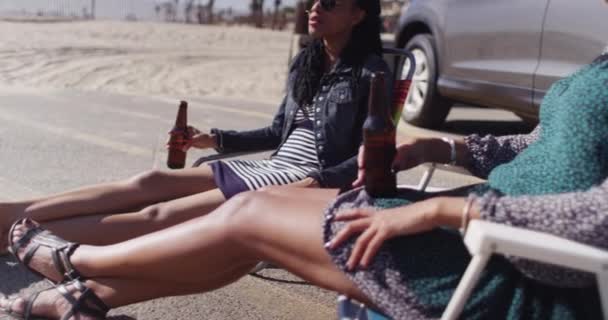 Γυναίκες Φίλες Που Κάθονται Στην Παραλία Χαμογελώντας Και Μιλώντας Πίνοντας — Αρχείο Βίντεο