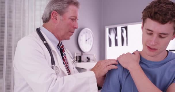 Starší Lékař Vyšetřuje Pohledného Muže Bělocha Který Trpí Bolestí Ramene — Stock video