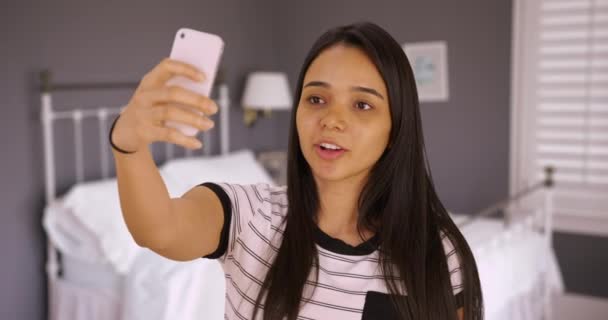 可愛い10代の若者が彼女の寝室で自撮りをする 少女はスマートフォンで自分の写真を撮る — ストック動画