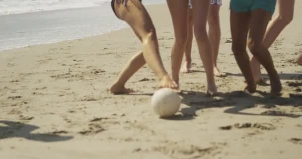 ビーチの海岸でボールを蹴る多民族の友人の本物の若いグループ — ストック動画