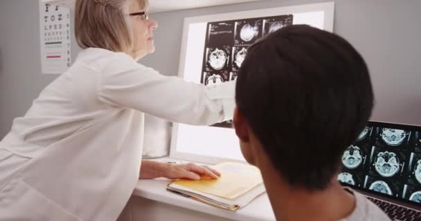 Junge Patientin Begutachtet Röntgenbilder Mit Reifem Arzt — Stockvideo