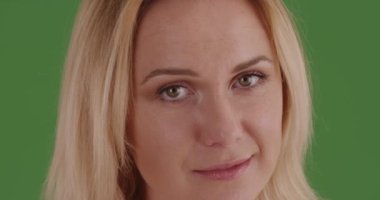 Yeşil ekranda kameraya bakan kadının yakın çekimi. Anahtar ya da birleşik olmak üzere yeşil ekranda.