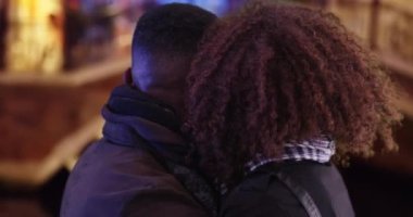 Geceleri Venedik 'i gezen çekici bir turist çifti. Mutlu Afrika kökenli Amerikalı çift Venedik caddesinde durup etrafa bakıp gülümsüyor. 4k