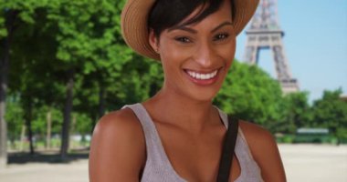 Mutlu genç Afrikalı kadın Paris, Fransa 'da mutlu bir şekilde poz veriyor. Genç, eğlenceli siyah kadın Eyfel Kulesi 'nin yakınındaki kameraya özgüvenle bakıyor. 4k