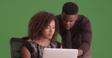 Afro-Amerikalı erkek ve kadın yeşil ekranda çalışıyor. Anahtar ya da birleşik olmak üzere yeşil ekranda.
