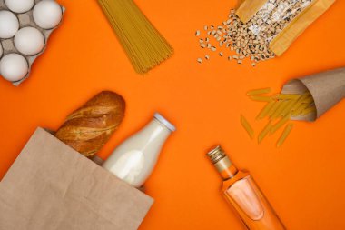 Ekmek ve bir şişe süt kağıt torbada. Yumurta, spagetti, makarna tüyleri, fasulye ve bir şişe zeytinyağı.