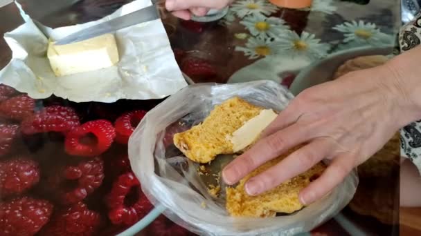 Женщина мажет масло на булочке, а затем кусает кусок, завтрак, 4K видео — стоковое видео