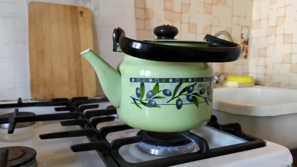 Зелений чайник кипить на газовій плиті. Затишна атмосфера в будинку . — стокове відео