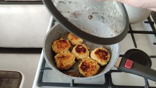 Chuletas de pollo en una sartén. El cocinero abre la tapa y la muestra. — Vídeos de Stock