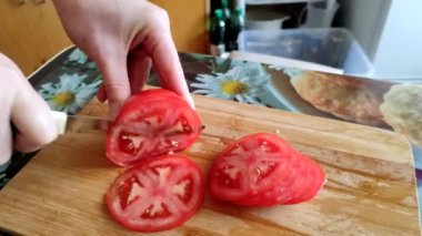 Kadın kesim tahtası üzerine domates kesiyor, 4K video.