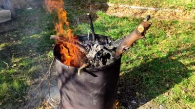 Kuru dallar fıçıda yanıyor. Sonbahar ve bahar temizliği.