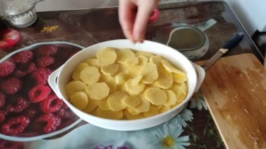 Kadın, fırında patates dilimlenmiş, 4K video.