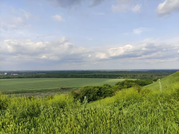 Manzara - vadi, tarlalar, orman ve gökyüzü bulutlarda