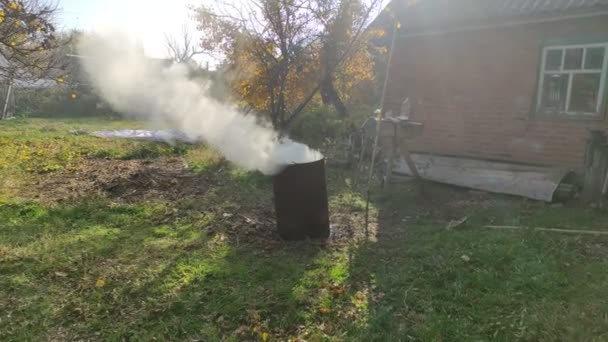 乾燥した枝は燃えており 樽で喫煙しています 秋と領土の春のクリーニング — ストック動画