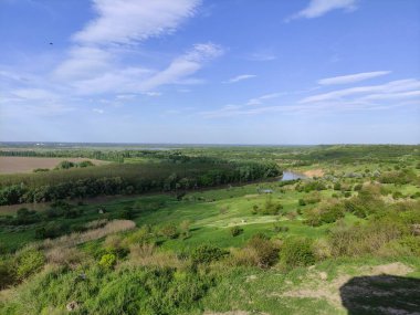Nehir, orman, tepeler ve bulutlu güzel gökyüzü olan yaz vadisi.