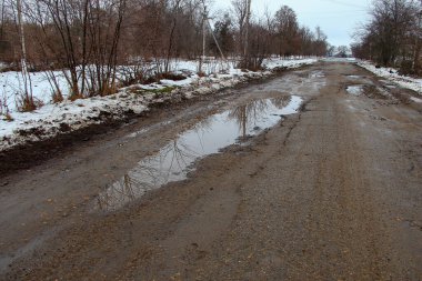 Kırsalda delikleri olan eski kötü asfalt yol.