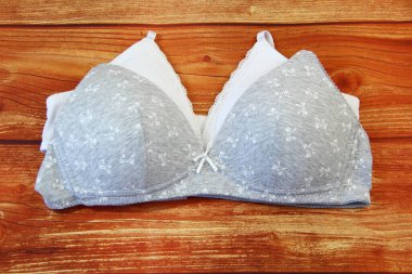 Ahşap arka planda beyaz ve gri sutyenler