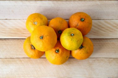 Ahşap arka planda taze mandalina yığını.