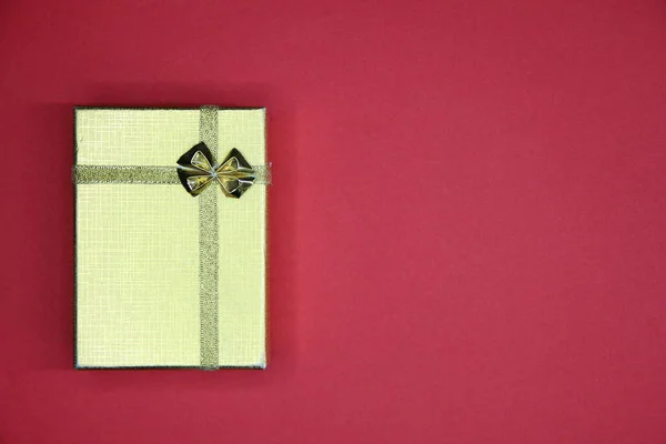 红色背景上带有复制空间的金色礼品盒 — 图库照片
