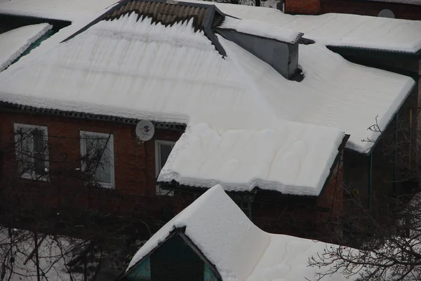 房子的屋顶 雪地上有黄色的污迹 — 图库照片