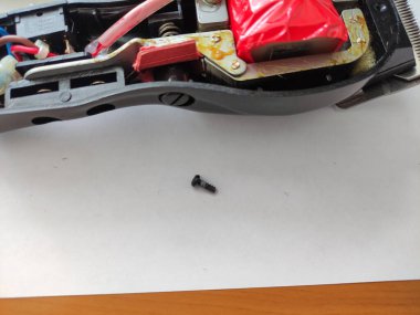 Bir masanın üzerinde parçalanmış elektrikli saç makası.