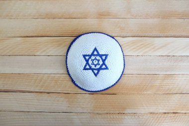 Yahudi kippah şapkası ve ahşap arka planda David 'in yıldızı var.
