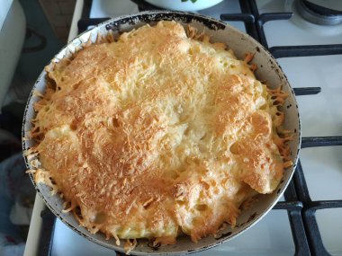 Tavada patates ve peynirli güveç.