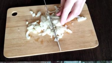 Aşçı kesme tahtasındaki soğanı keser.