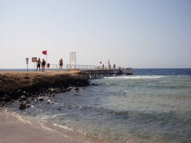 Denizde dalgalar ve sahilde cankurtaran bayrağı