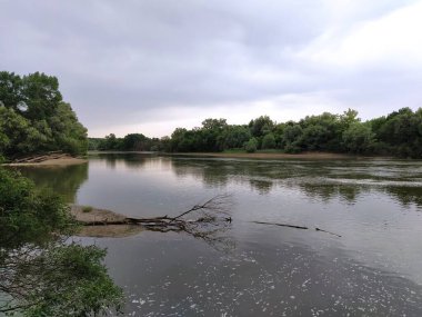 Geniş orman nehri gökyüzü ve bulutların arka planına karşı