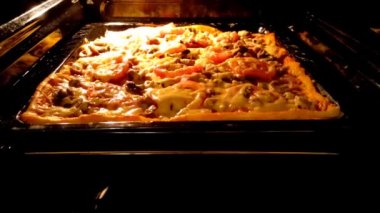 Pizza sıcak gaz fırınında pişiyor, yakın çekim 4K video.