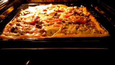 Pizza sıcak gaz fırınında pişiyor, yakın çekim 4K video.