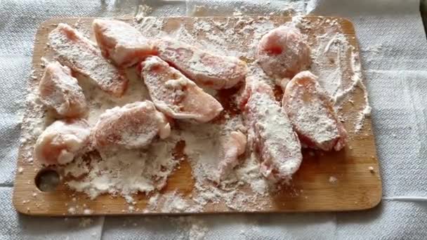 Κομμάτια στήθους κοτόπουλου σε αλεύρι σε ξύλο κοπής — Αρχείο Βίντεο