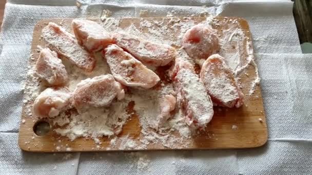 Morceaux de poitrine de poulet hachée dans la farine sur la planche à découper en bois — Video