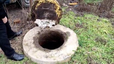 Adam bir foseptik tankı gösteriyor ve sonra fosseptik tankının kapağını kapatıyor, 4K video.