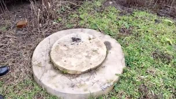 Man opent een septic tank luik in de tuin, in de winter of herfst, 4K video — Stockvideo