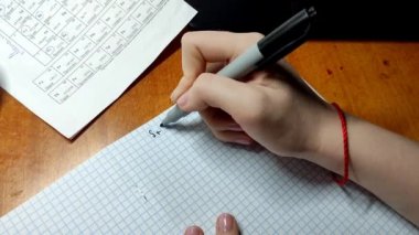 Kadın eli bir deftere kimyasal formüller yazıyor, yakın plan, 4K video.