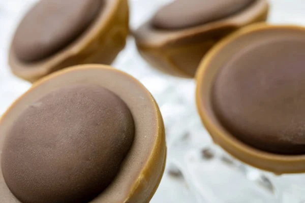 Crunchy hazelnut in caramel with nougat cream and a drop of dark chocolate on top.