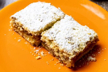 Sonbahar sezonunda bir tabağa şeker serpiştirilmiş elmalı turta.