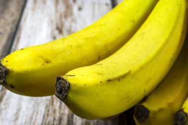 Tahta bir masada taze muzlar.