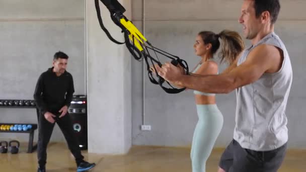 Personal Trainer ermutigt Kniebeugen mit Sprüngen in der Sporthalle. — Stockvideo