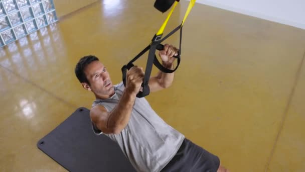 Un hombre fuerte hace flexiones inclinadas en un gimnasio. — Vídeos de Stock