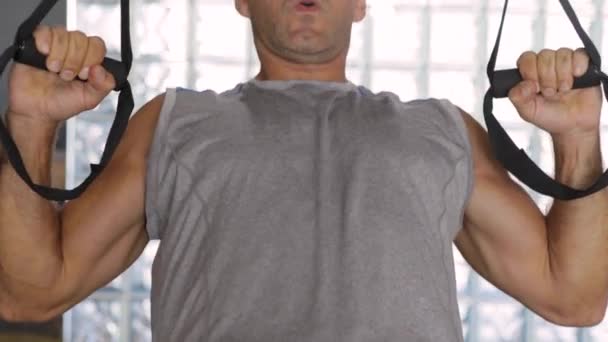 Un hombre fuerte en forma hace flexiones inclinadas en un gimnasio, ejercitando los músculos del brazo. — Vídeos de Stock
