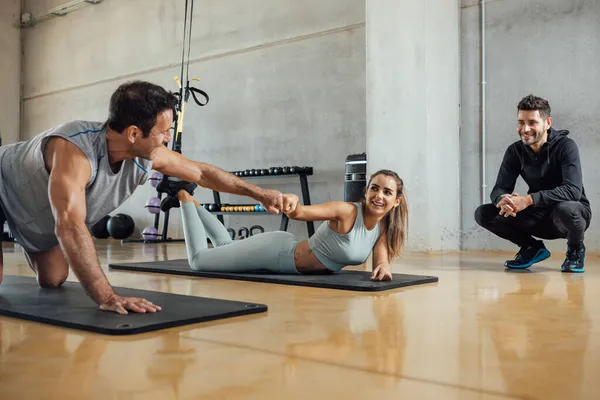Hombre de fitness y amigos de la mujer hacen golpe de puño en el gimnasio después del entrenamiento. — Foto de Stock