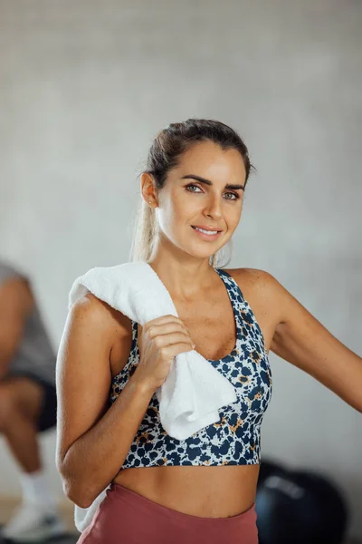 Retrato de la joven confiada sonriente de pie en el gimnasio mirando a la cámara. — Foto de Stock