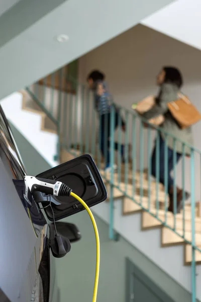 Close-up van geplugde kabel opladen van een elektrische gezinsauto in een bepaalde garage — Stockfoto