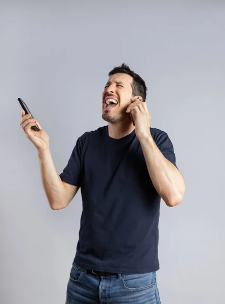 Hombre enojado con dos teléfonos inteligentes grita durante la conversación. —  Fotos de Stock